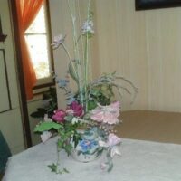 Fake Flowers in a Pink, Blue, Green & White Pot
